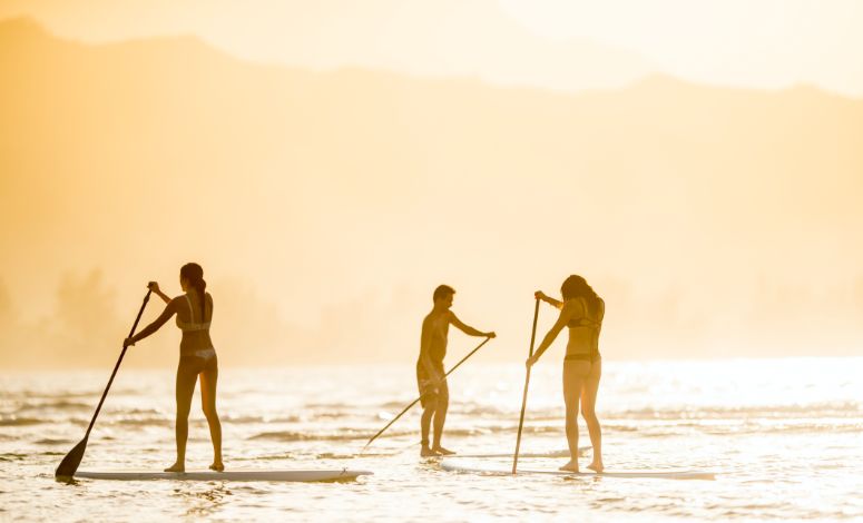 3 people stand-up paddling